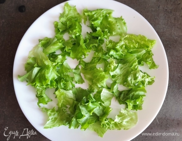 На большую тарелку рвем и выкладываем листья салата (предварительно вымыть, обсушить).