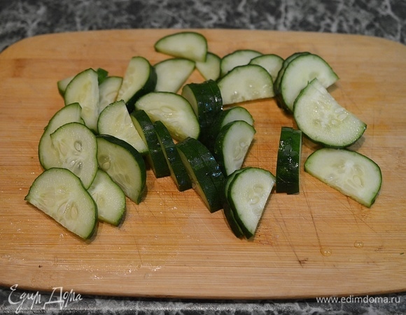 Свежие огурцы также вымойте, обсушите и нарежьте дольками.