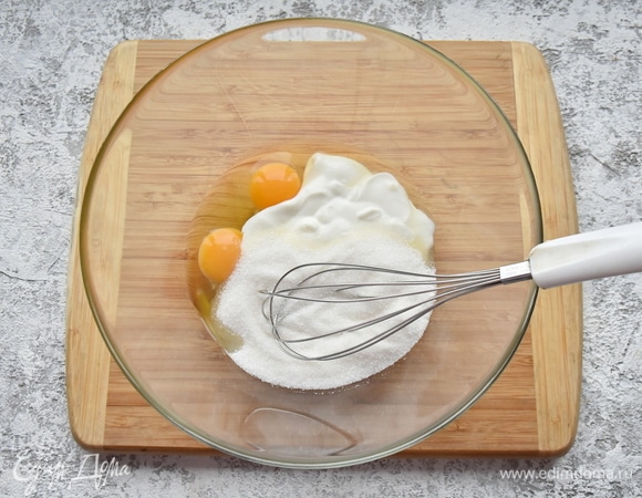 В миске соединить яйца, сметану, сахар. Размешать венчиком, не взбивая.