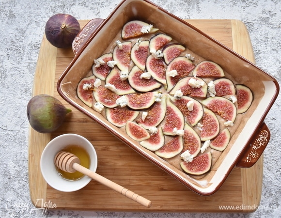 Инжир нарезать и выложить в произвольном порядке на тесто. Раскрошить сверху сыр и полить жидким медом. По желанию можно посыпать верх дробленым орехом. Выпекать в духовке, разогретой до 180°C, 40–45 минут. Готовность проверить лучинкой.