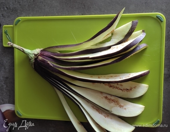 Разрезать каждую половинку вдоль на полоски шириной 5 мм, не дорезая до хвостика примерно 1 см. Натереть солью, чтобы баклажан пустил сок и стал мягким, оставить на 20 минут.