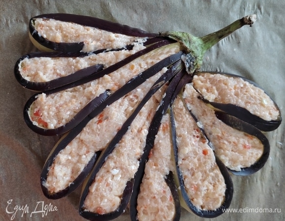 Промыть баклажаны от соли, просушить бумажным полотенцем. Каждую полоску баклажана смазать растительным маслом, согнуть и прижать к следующей, уложить в форме «хвоста», заполнить фаршем. Выложить на пергамент, запекать в разогретой до 180°C духовке примерно 30–40 минут. Ориентируйтесь по своей духовке, они у всех разные.