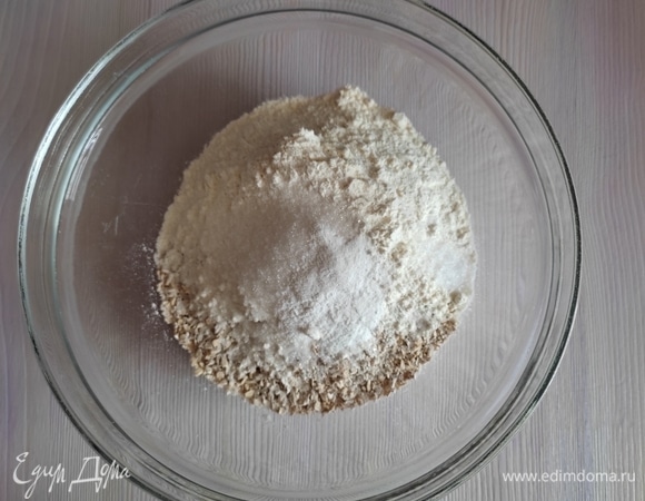 В чашке при помощи венчика смешиваем просеянную с разрыхлителем муку, овсяные хлопья, сахар и соль.