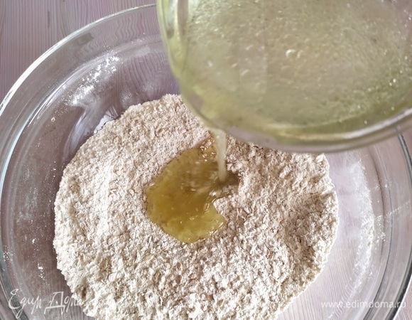 Влить воду с маслом в сухую смесь и замесить тесто.