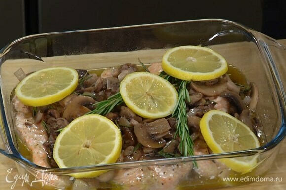 Запеченную рыбу полить грибным соусом, украсить веточками свежего розмарина и лимоном.