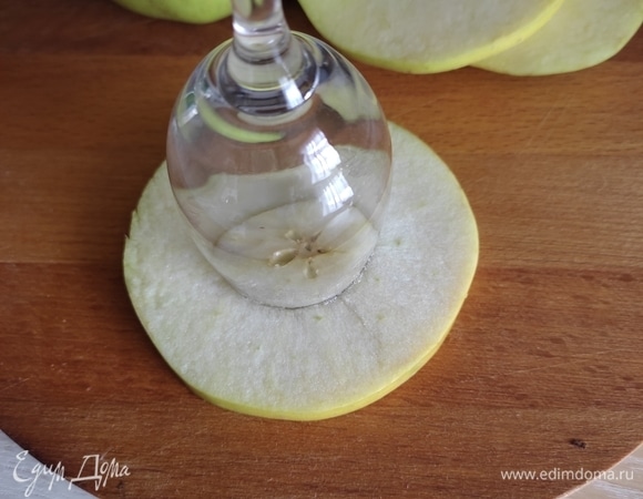 Рюмкой подходящего размера сделать отверстие посередине яблока.