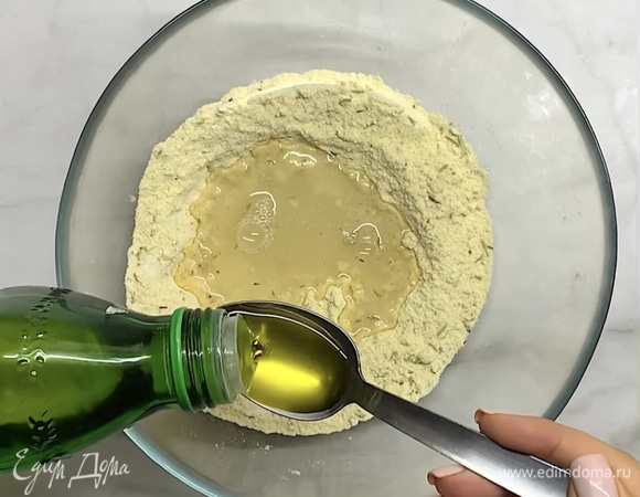 В воде растворяем соль и вливаем в муку, добавляем оливковое масло. Вымешиваем тесто, собираем в плотный шар.