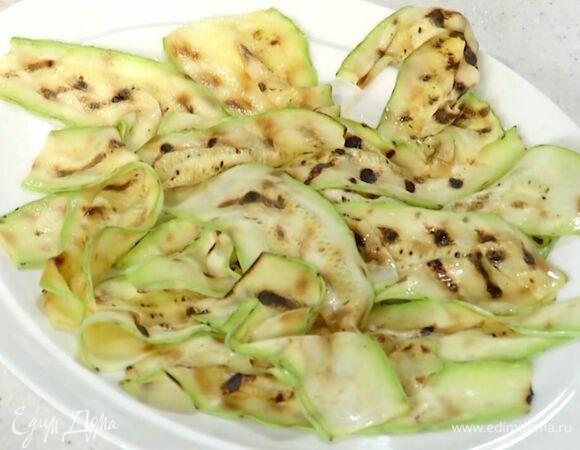 Кабачок нарезать тонкими полосками и обжарить на смазанной оливковым маслом сковороде-гриль. Фету порезать небольшими кусочками. Твердый сыр натереть на крупной терке. Укроп мелко порубить.<br />
 