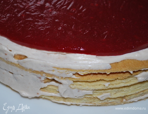 Соберите торт, промажьте коржи кремом. В середину торта выложите малиновый слой и покройте его небольшим количеством крема.
