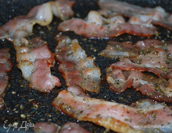 На хорошо разогретой сковороде обжарьте бекон с обеих сторон, добавьте щепотку сушеного орегано.