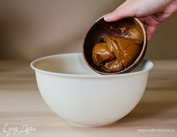 Не прекращая взбивать, добавить частями вареное сгущенное молоко.