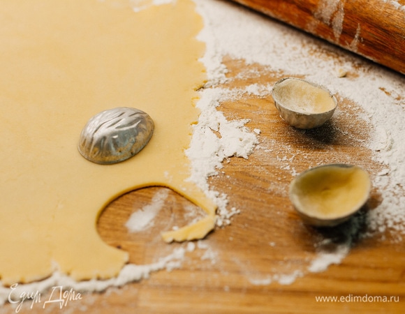 Тесто раскатать скалкой в пласт толщиной 4–5 мм. Вырезать при помощи формочек овалы. Каждый овал поместить внутрь формочки и хорошо примять пальцами (так, чтобы тесто проникло во все бороздки формочки, и у готового печенья на поверхности был рельефный рисунок).