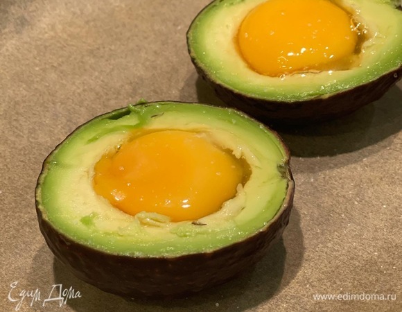 Разрезаем авокадо, вынимаем косточку и немного мякоти по кругу, чтобы поместилось яйцо. Если авокадо небольшое, можно убрать часть белка. Вливаем яйцо в авокадо, солим и отправляем в духовку, разогретую до 180°C, минут на 10–15. Как только белок схватится, значит, готово.