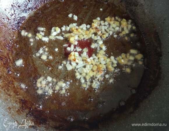 Свинину откинуть на бумажные полотенца, чтобы стек жир. В той же сковороде обжариваем чеснок и имбирь 1–2 минуты. Добавить кунжутное масло. Вся обжарка идет на максимальном огне.