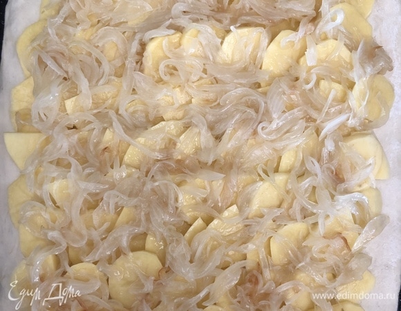 Пока тесто поднимается, нарезаем 2 крупные луковицы перьями или полукольцами. Тушим с добавлением растительного масла до готовности. Нарезаем куриное филе крупным кубиком и маринуем в смеси соли, укропа и небольшого количества растительного масла. Чистим картофель и нарезаем кружочками. Подошедшее тесто делим на 2 части: побольше и поменьше. Большую часть раскатываем в пласт — это будет нижний корж. Перекладываем на смазанный маслом противень, сверху выкладываем картофель, солим по вкусу. Затем — лук.