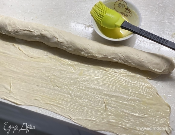 Далее раскатать тесто в пласт толщиной 0,5 мм. Смазать растопленным сливочным маслом. Свернуть в плотный рулет.