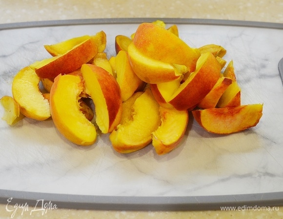 Персики вымойте, удалите косточки и нарежьте дольками.