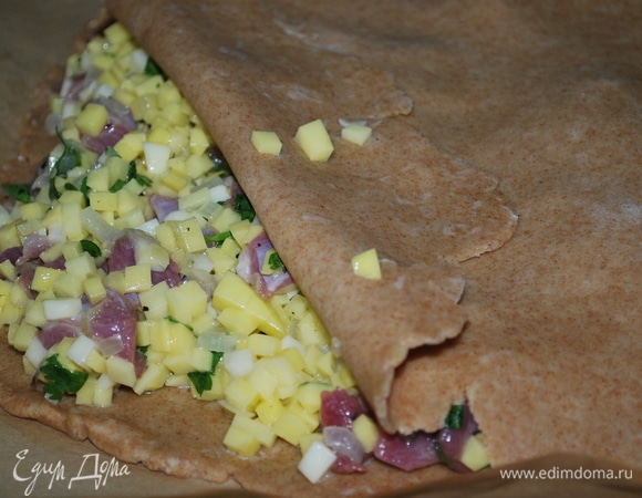 Десто разделите на 2 части, раскатайте их с помощью скалки. Пергамент выложите на противень и сформируйте на нем пирог, хорошо защипните края теста. Сделайте небольшое отверстие в середине пирога для выхода пара. Выпекайте пирог в предварительно разогретой духовке при 170°C в течение 45–50 минут, до готовности.