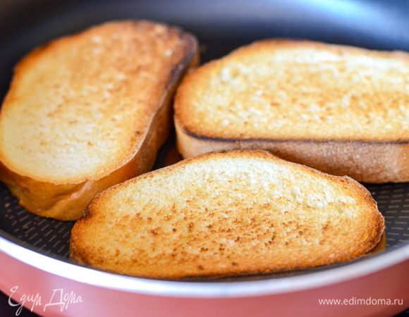 Батон поджарить на сухой сковороде или в тостере до румяности.
