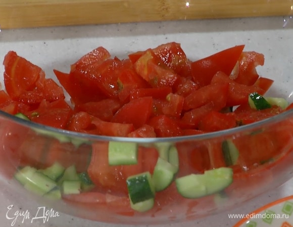 Помидоры и огурцы разрезать пополам и, удалив сердцевину с семенами, нарезать небольшими кусочками.