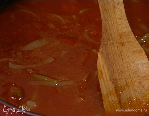 Разогреть в сковороде оставшееся оливковое масло, выложить лук и чеснок и томатную пасту, перемешать и обжарить, затем добавить помидоры в собственном соку, все посолить, влить вино, довести до кипения и дать алкоголю выпариться.