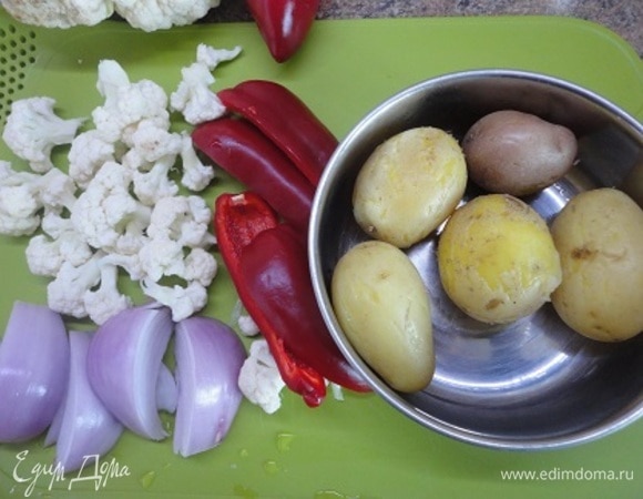 Картофель отварить в течение 10 минут. Перед запеканием разрежьте. Подготовьте овощи. Разогрейте духовку до 200°C.