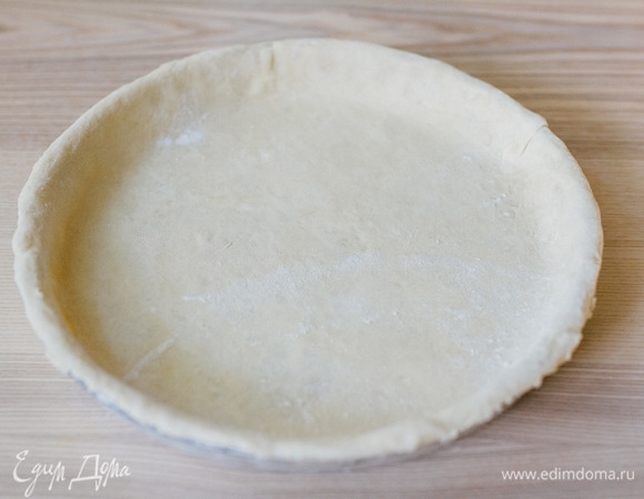 Форму для пирога смазать сливочным маслом. Тесто раскатать в круг и переложить в форму, сформировав бортики.