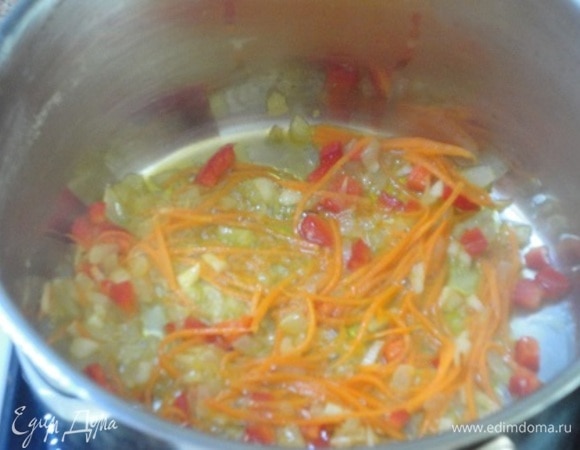 В кастрюле с толстым дном разогреть сливочное масло и потушить до мягкости лук и чеснок. Добавить морковь с перцем и тушить еще пару минут.
