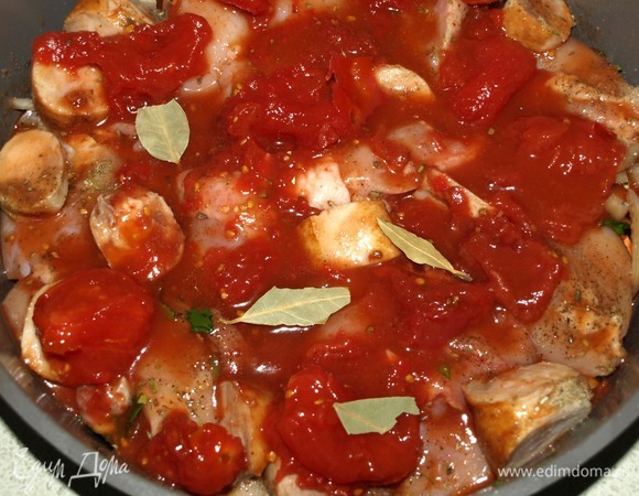 Добавляем вино и помидоры в собственном соку (вес в ингредиентах указан вместе с соком). Если помидоры с кожицей, то ее лучше снять. Добавляем лавровый лист (не обязательно). Закрываем форму фольгой и отправляем в заранее разогретую до 175ºС духовку на 1,5 часа. Через 1,5 часа снять фольгу, и оставить в духовке еще на 30 минут.