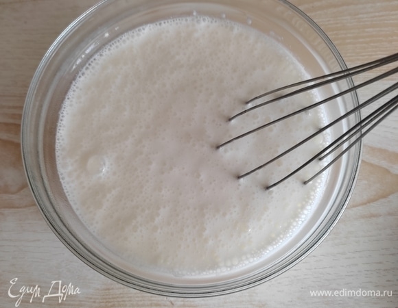 В подогретый кефир добавить сахар, соль, соду и хорошо перемешать. Масса станет пышной, со множеством пузырьков и увеличится в объеме. Оставить на 5 минут.