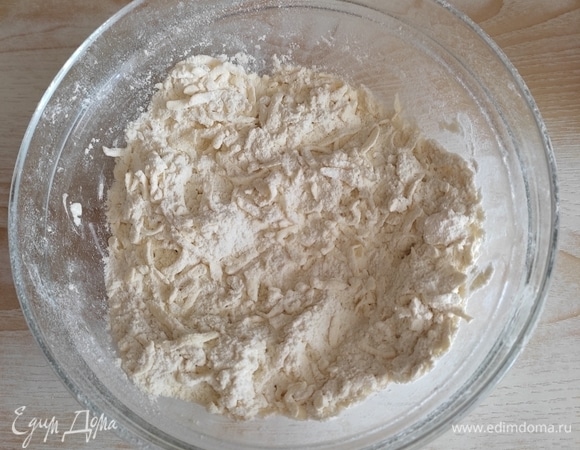 Просеять 200 г муки и натереть в чашу сливочное масло на крупной терке, смешать с мукой. Для теста необходимо масло из морозилки!