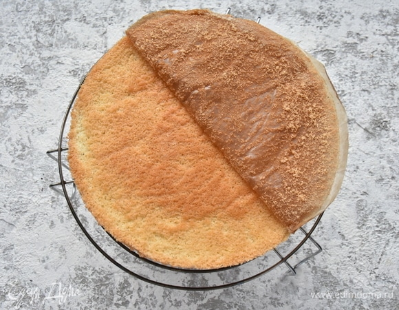 Выпекаю бисквит в духовке, разогретой до 170°C. Готовность проверяю лучинкой. Даю бисквиту полностью остыть на решетке и извлекаю из формы. Удаляю пергамент. Оборачиваю бисквит пищевой пленкой и оставляю до момента сборки торта.