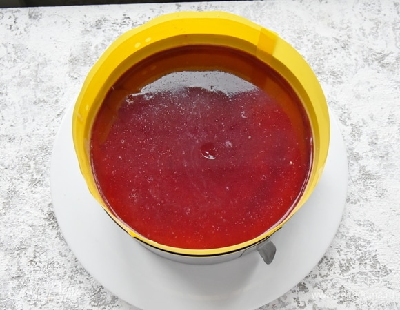 Собираю торт. Бока формы выстилаю пленкой. Для этой цели отлично подходят ленты, нарезанные из пластиковых скоросшивателей. На дно формы кладу бисквит. Бока прокладываю половинками нарезанных ягод клубники, плотно прижимая к пленке. Заполняю остальное пространство заварным кремом, не забывая заполнить промежутки между половинками клубники. Выложив половину крема, распределяю поверх ягоды клубники. Ее можно использовать целиком либо произвольно нарезать. Поверх ягод выкладываю большую часть оставшегося крема и разравниваю поверхность. Сверху укладываю второй бисквитный корж. Остатки крема распределяю по поверхности коржа. Для желе можно использовать готовый полуфабрикат или сварить его самостоятельно из той же клубники с добавлением желатина. Залить поверхность торта желе и поставить изделие в холодильник для стабилизации.