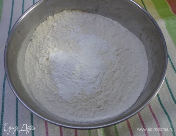 В первую очередь разогрейте духовку до 180°C. Сливочное масло растопите и оставьте остывать. Муку смешайте с крахмалом, разрыхлителем и 1 щепоткой соли.