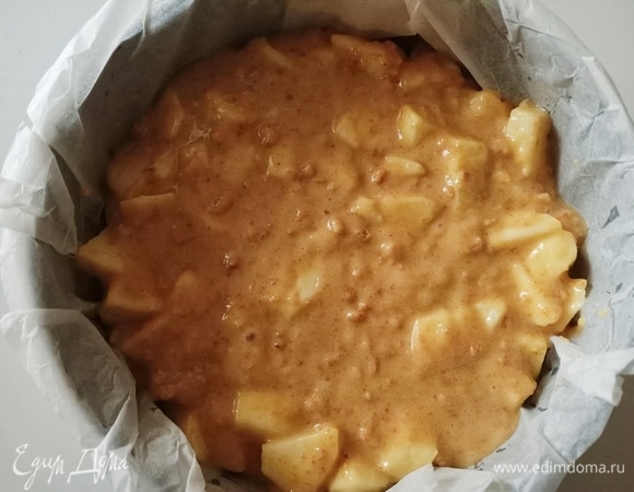 Очистить и нарезать небольшими кусочками 2 яблока. Затем добавить их в тесто и перемешивать в течение нескольких минут. Сначала тесто получается очень густым, но затем яблоки выделяю сок и мешать все становится легче. Форму застелить пекарской бумагой и выложить тесто.