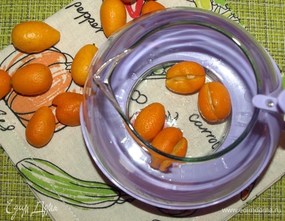 Кумкват надрезать и отправить в чайник. Немного примять.