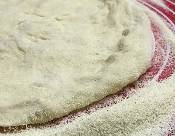 Выкладываем на поверхность, посыпанную манкой, и начинаем растягивать руками или раскатывать. Получится одна пицца диаметром 25 см.