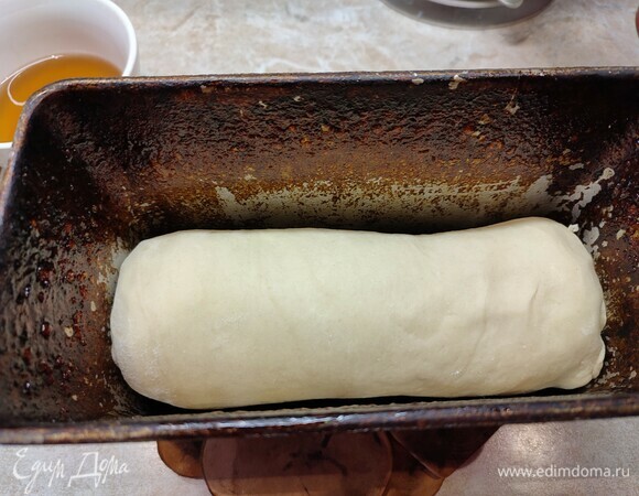 Раскатать тесто в пласт толщиной примерно 5 мм и шириной размером с форму. Скатать в тугой рулет и положить в форму швом вниз. Накрыть полотенцем и оставить при комнатной температуре на 2 часа.