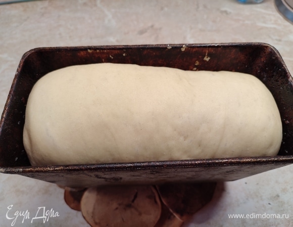 Духовку разогреть до 230°C и сразу поставить в нее железную миску, чтобы она тоже нагревалась. Как только духовка разогреется, влить в миску стакан воды и сразу поставить хлеб на 10 минут. Убавить температуру до 200°C и выпекать еще 30 минут.