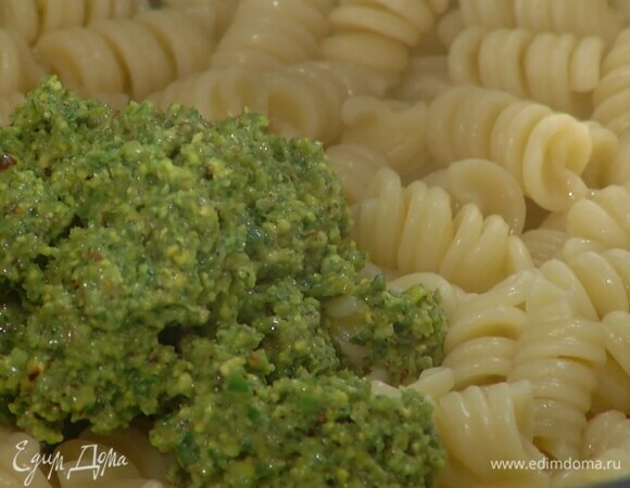 Из макарон слить воду и вмешать в них соус песто, затем добавить авокадо и еще раз перемешать, выложить пасту в глубокое блюдо, сбрызнуть оставшимся оливковым маслом и украсить листьями базилика.