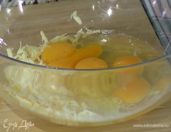 Сыр натереть на крупной терке, треть отложить, к остальному сыру добавить яйца, все перемешать, посолить и поперчить.