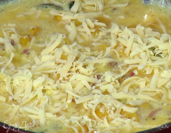 К тыкве в сковороду влить яичную смесь, перемешать и прогревать на небольшом огне, пока края не начнут схватываться, затем посыпать фриттату оставшимся сыром и отправить в разогретую духовку на 3–4 минуты.