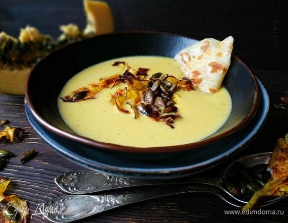 Горячий крем-суп разлейте по тарелкам, добавьте тыквенные чипсы и семечки, подавайте к столу. Приятного аппетита.
