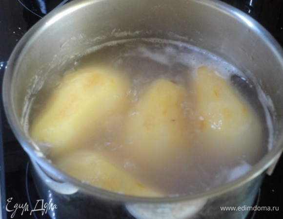 Груши очистить от кожицы, залить водой, чтобы она только покрывала их, добавить 50 г сахарной пудры. Довести до кипения, уменьшить нагрев и варить 10–12 минут. Включить духовку для разогрева на 180°C.