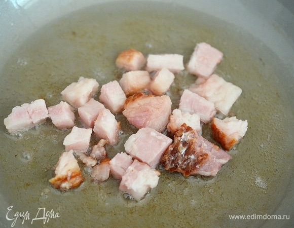 Пока варится пшено, нарежьте бекон на кубики. Можно взять сырокопченый, варено-копченый и даже сырой бекон. Обжарьте на сковороде до хрустящего состояния. Добавьте бекон к пшену.