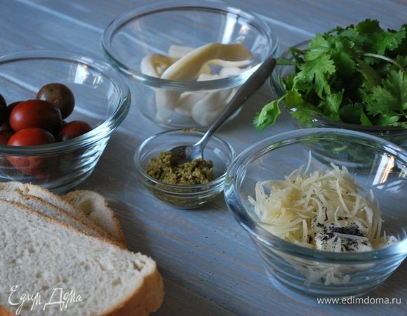 Для бутербродов понадобятся: помидоры черри (можно заменить на обычные помидоры), соус песто, свежая зелень по вкусу, сливочное масло, сыр (у меня сыр чечил и твердый сыр), булка и ароматные травы по вкусу.