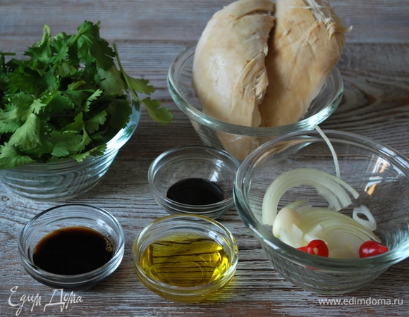 Подготовьте продукты для салата. Свежую зелень кинзы вымойте, лук почистите и нарежьте тонкими полукольцами, зубчик чеснока мелко порубите. Куриную грудку нарежьте небольшими полосками (у меня куриная грудка готовая, осталась после запекания курицы в духовке). У перца чили удалите семена и нарежьте тонкими полосками.