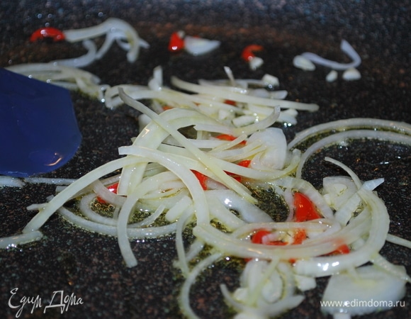 Сковороду с толстым дном хорошо разогрейте, добавьте оливковое масло и обжаривайте лук, чеснок и чили примерно 3–4 минуты, периодически помешивая.