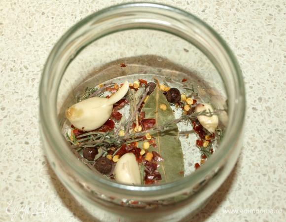 В сухую чистую банку кладем лавровый лист, чеснок, перец горошком, перец чили, орегано, тимьян и розмарин.