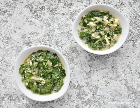 Формочки для запекания смазываю сливочным маслом и распределяю яичную смесь. Накрываю верх формочек фольгой. Запекаю яйца в разогретой до 180°C духовке 10–15 минут.